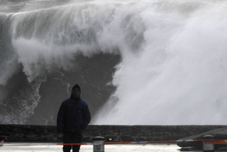 FOTOGALERÍA DEL TEMPORAL | En la foto, un hombre camina cerca de las olas en la costa de Muxía (A Coruña)