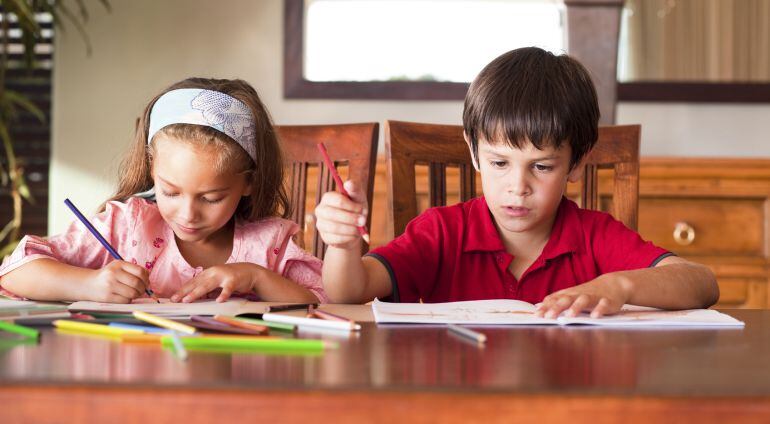 Dos niños haciendo sus deberes.