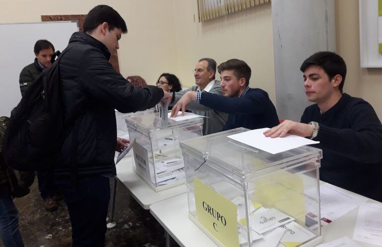 Un estudiante vota en la mesa electoral para estudiantes y profesores de la facultad de Derecho