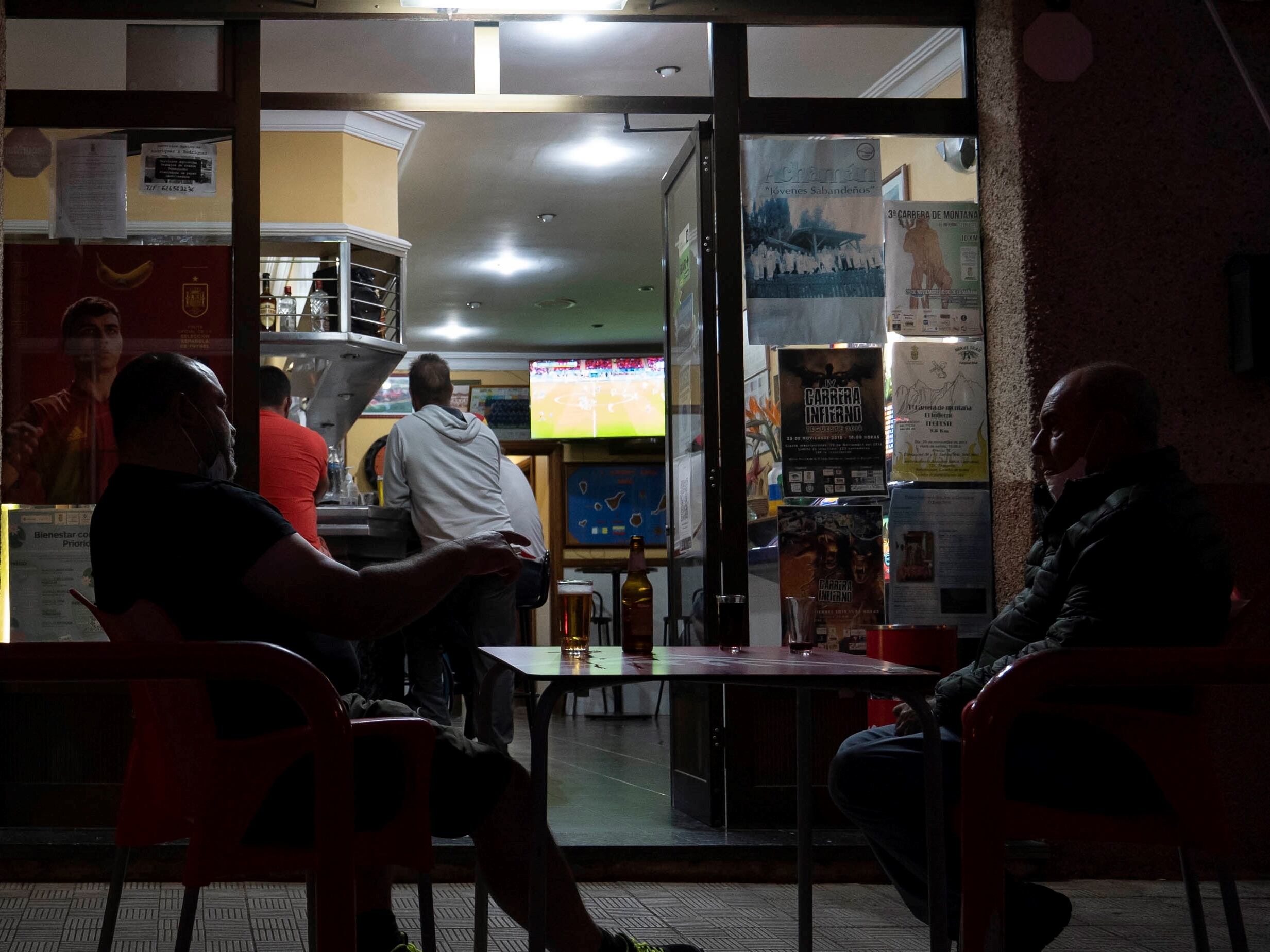 Varios aficionados viendo futbol en un bar