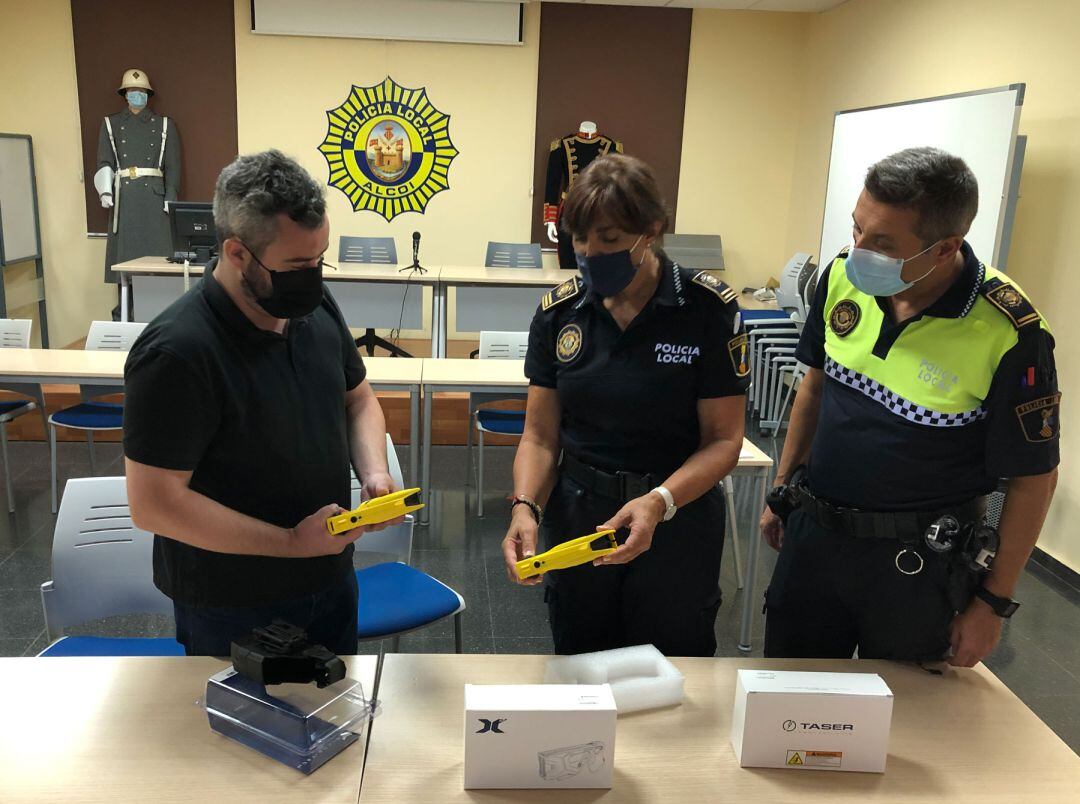 El concejal de Seguridad, Raül Llopis, observa dos de estas pistolas junto a agentes de la Policía Local