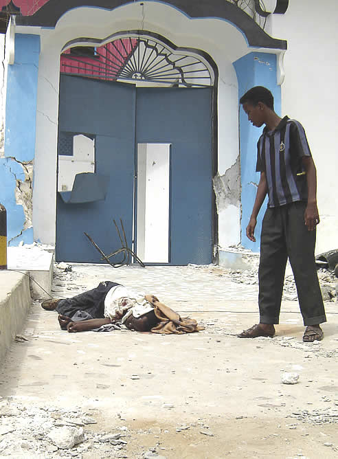 Un joven mira el cadáver de uno de los fallecidos en los enfrentamientos.