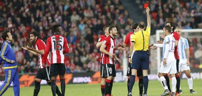 El árbitro Alvaro Izquierdo saca targeta roja al defensa del Athletic de Bilbao Mikel San José en partido frente al Málaga CF, correspondiente a la decimocuarta jornada de la Liga BBVA disputado en San Mamés. 