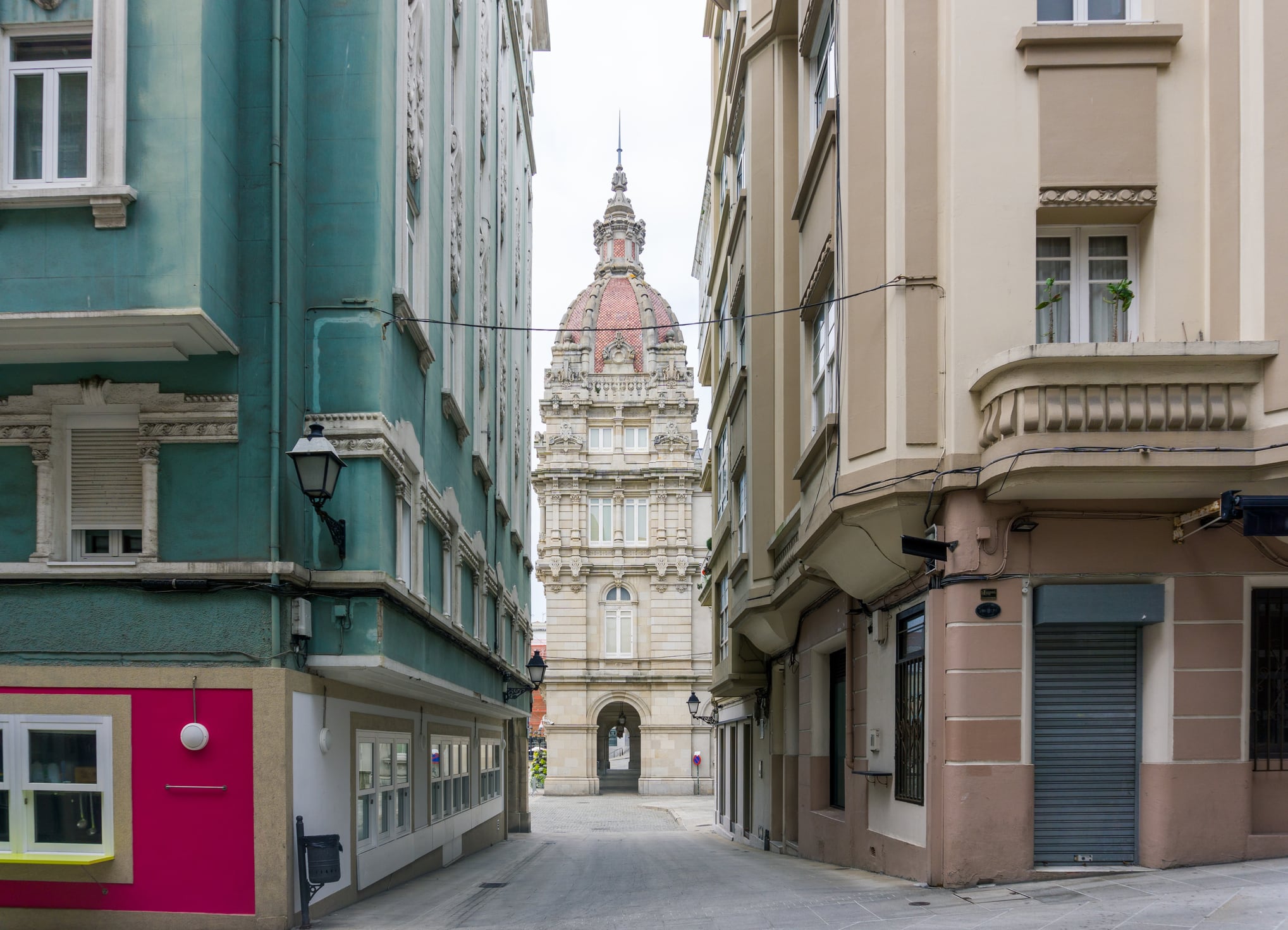 Urban landscape of a street in the historic center of the city of A Coruña with one of the towers of Plaza de María Pita in the background