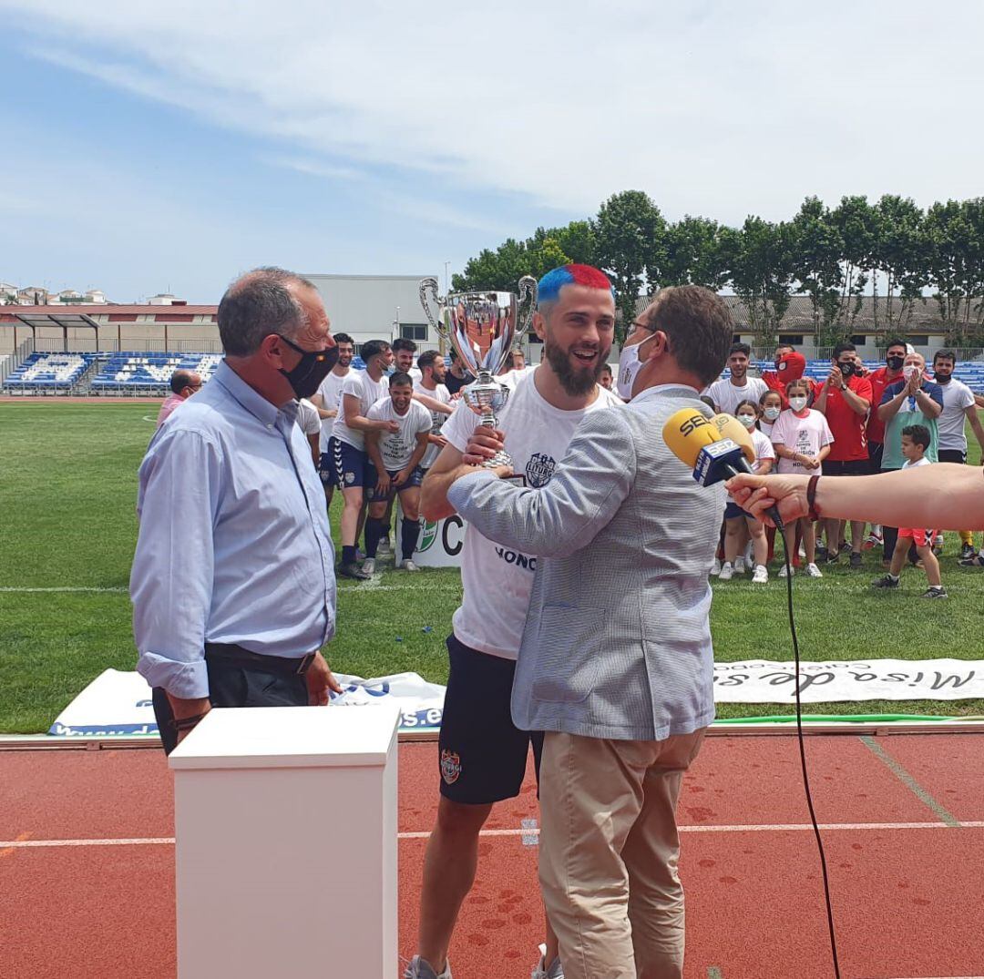 El capitán del Iliturgi CF, Javi Espallargas, recibe de manos del alcalde de Andújar, Francisco Huertas, el trofeo de campeón en presencia del delegado de la FJF, Ildefonso Ruiz.