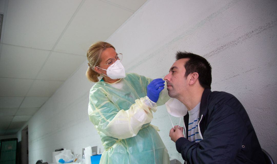 Una sanitaria realiza un test de antígenos o una PCR