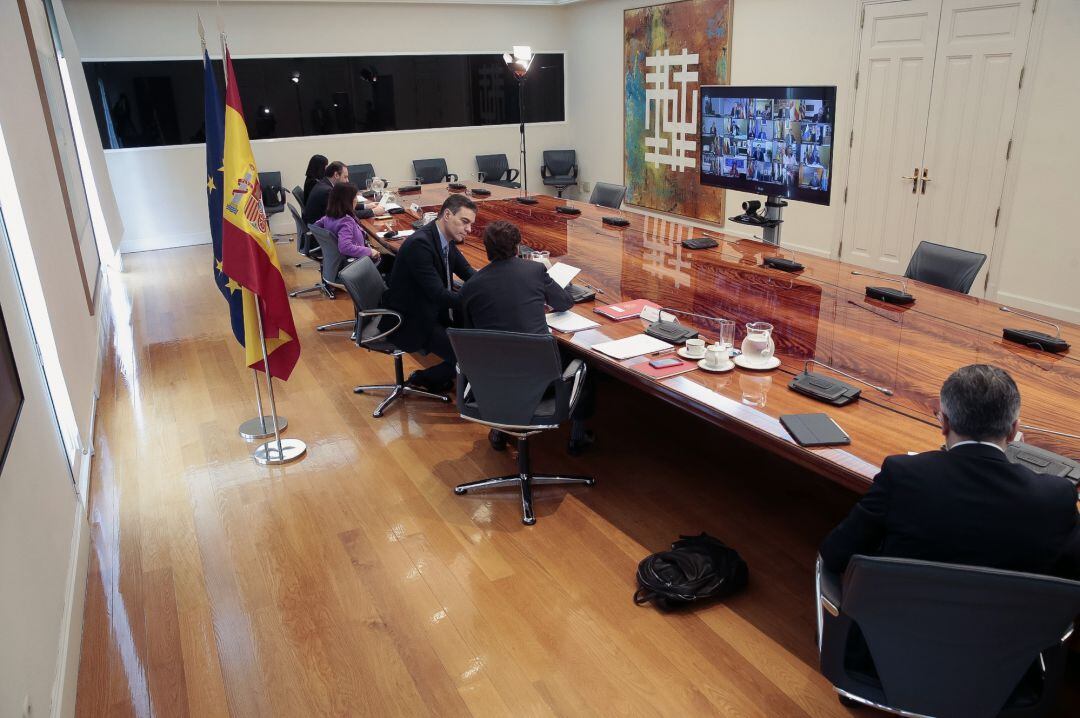 Fotografía facilitada por Moncloa que muestra al presidente del Gobierno, Pedro Sánchez (c-i) mientras conversa con el ministro de Sanidad, Salvador Illa (c-d) durante la videoconferencia de presidentes autonómicos