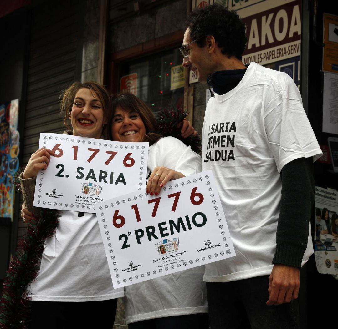 Los dueños de la administración de lotería de Urdiliz, muestran su alegría tras haber repartido el segundo premio del sorteo extraordinario de El Niño, dotado con 750.000 euros por serie (75.000 euros al décimo) que ha correspondido al número 61.776 y que se encuentra muy repartido, ya que ha sido vendido en numerosas administraciones de toda España.. 
