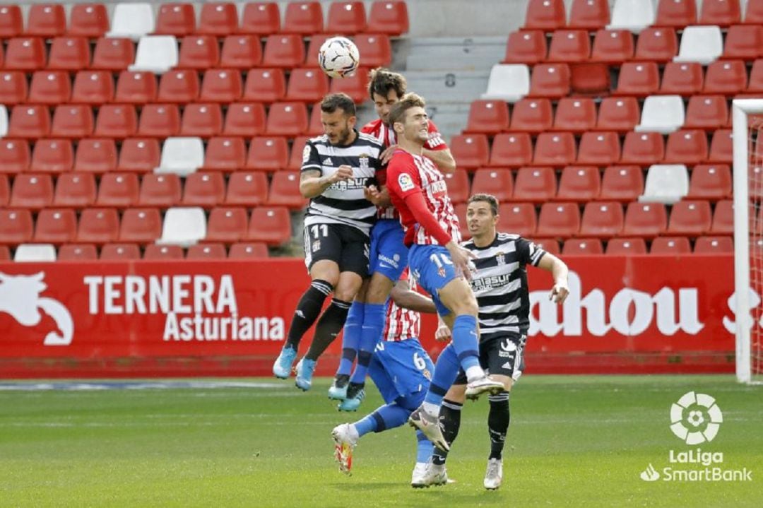 Marc Valiente y Gragera disputan un balón aéreo con el delantero del Cartagena Elady.