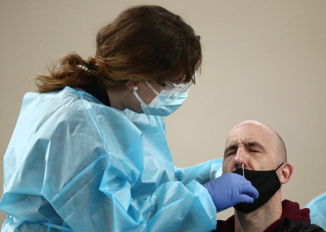 Una trabajadora sanitaria protegida realiza uno de los primeros test de antígenos de SARS-CoV-2 en el polideportivo del Campus Sur de Vallecas de la Universidad Politécnica, este jueves.
