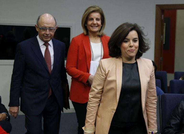 La vicepresidenta del Gobierno, Soraya Saenz de Santamaría (d) acompañada por los ministros de Hacienda y de Empleo, Cristóbal Montoro y Fátima Báñez, respectivamente, a su llegada a la rueda de prensa posterior a la reunión del Consejo de Ministros