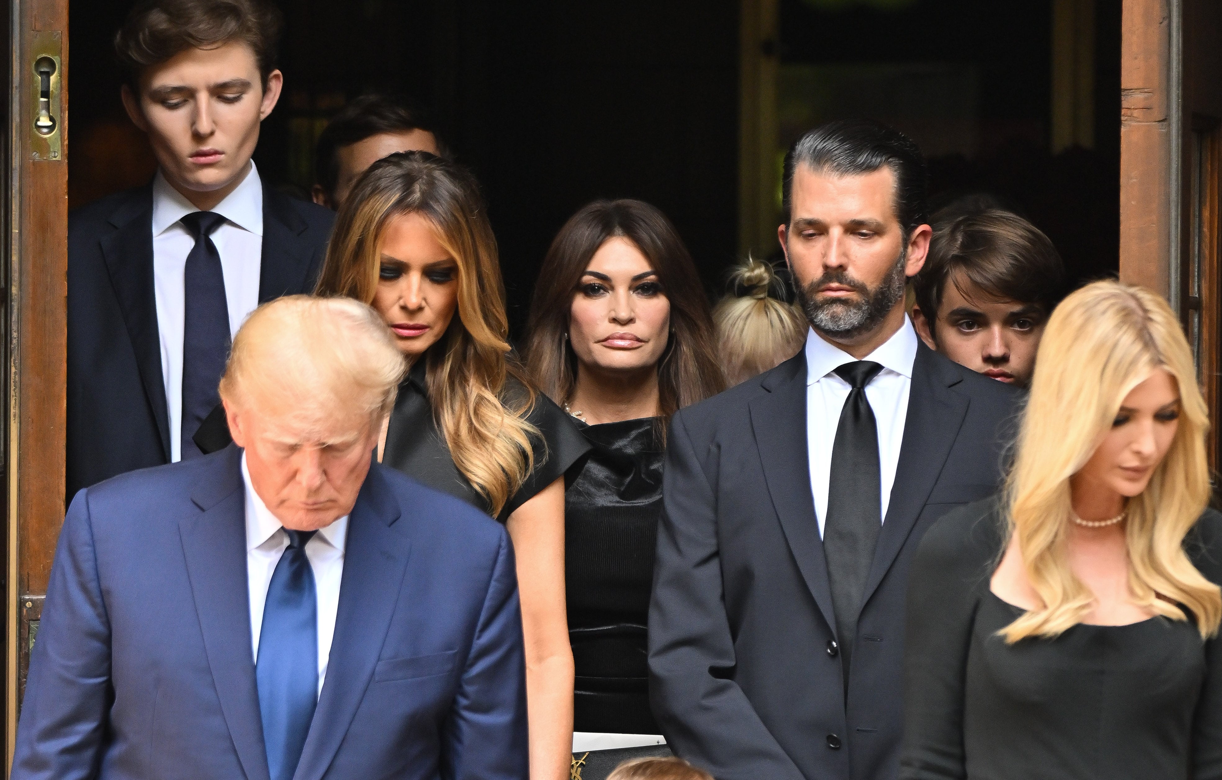 Donald Trump Jr. (con barba) detrás de su padre en un acto en Nueva York