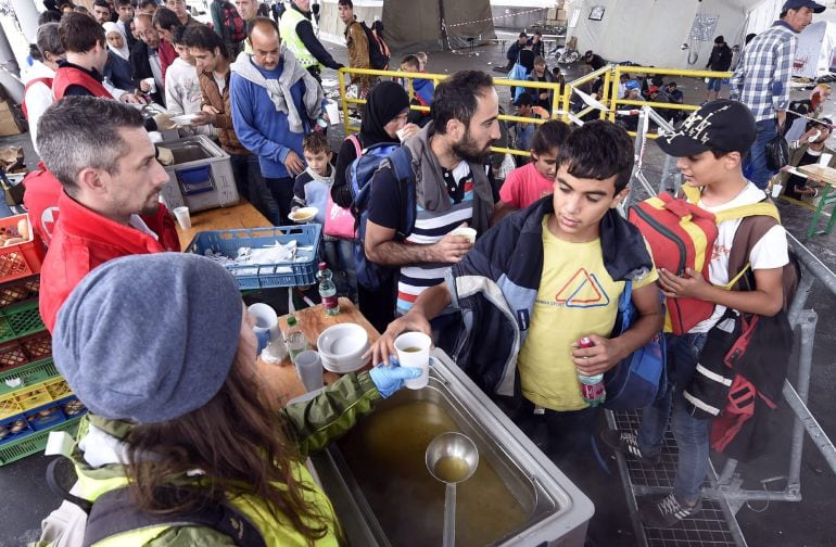 Refugiados reciben comida de manos de voluntarios de la Cruz Roja en Nickelsdorf (Austria)