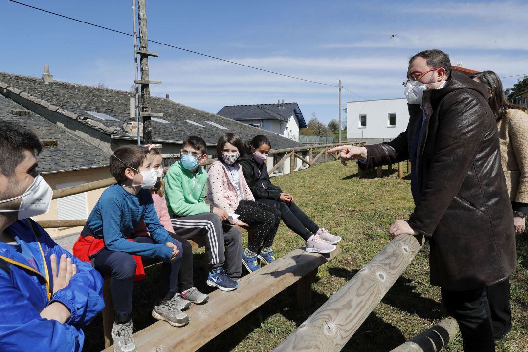 El presidente del Principado, Adrián Barbón, conversa con un niños durante su visita a Allande. 