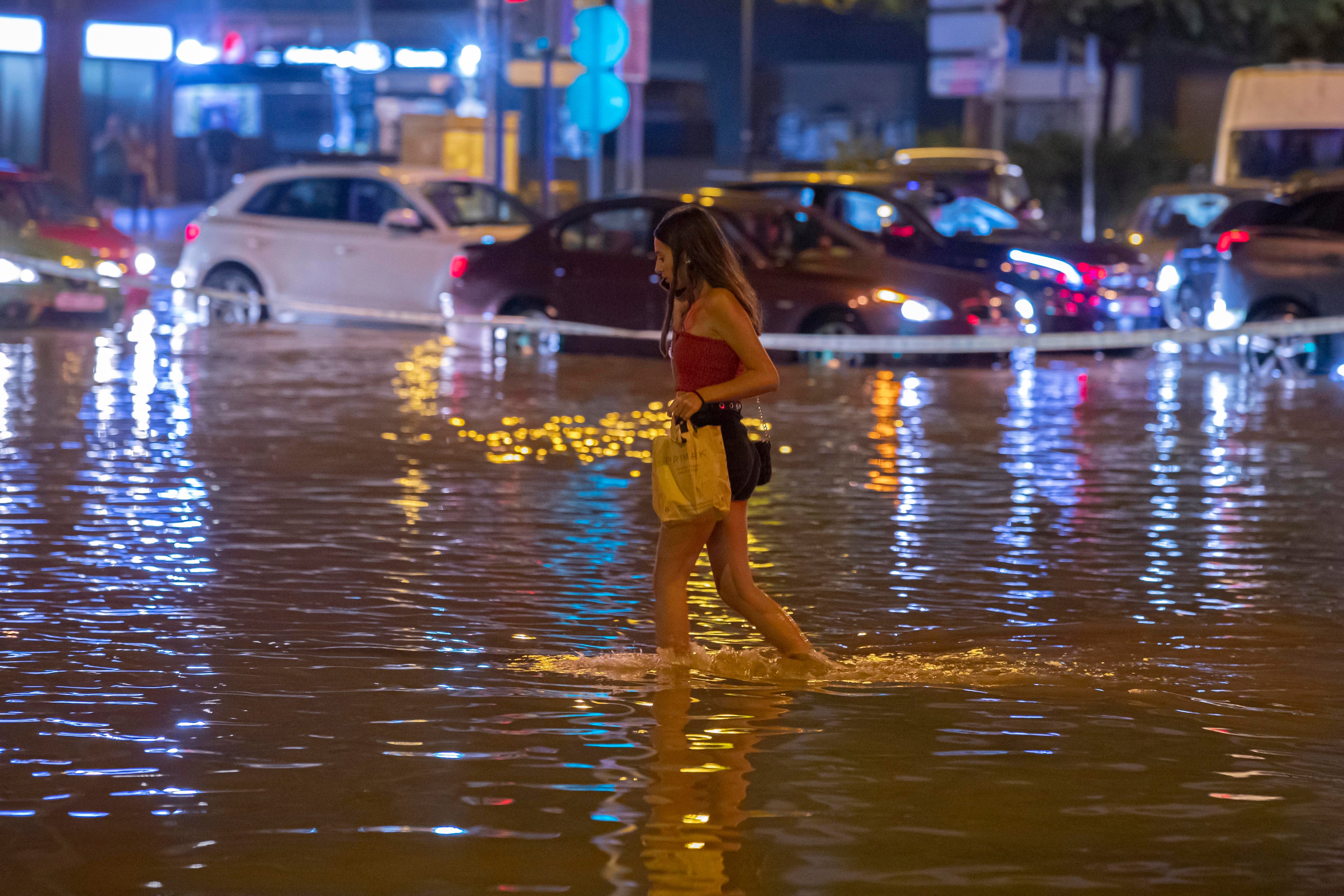 MURCIA, 15/09/2023.- Una joven cruza la avenida Juan de Borbón de Murcia, inundada tras la tormenta de este viernes. EFE/ Marcial Guillén
