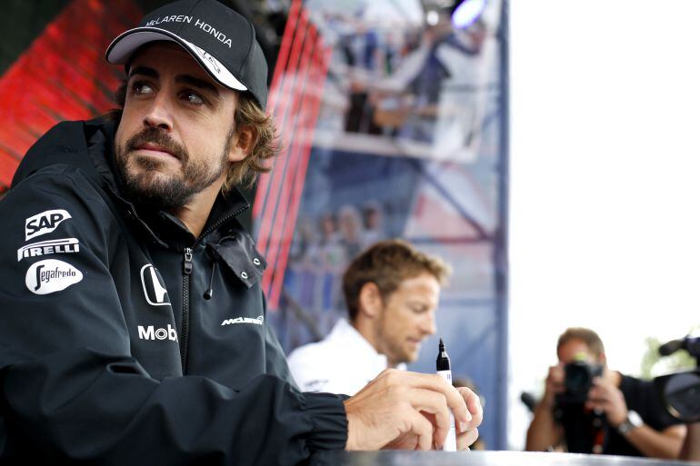 Fernando Alonso y Jenson Button firman autógrafos en la primera jornada del GP de Austria.