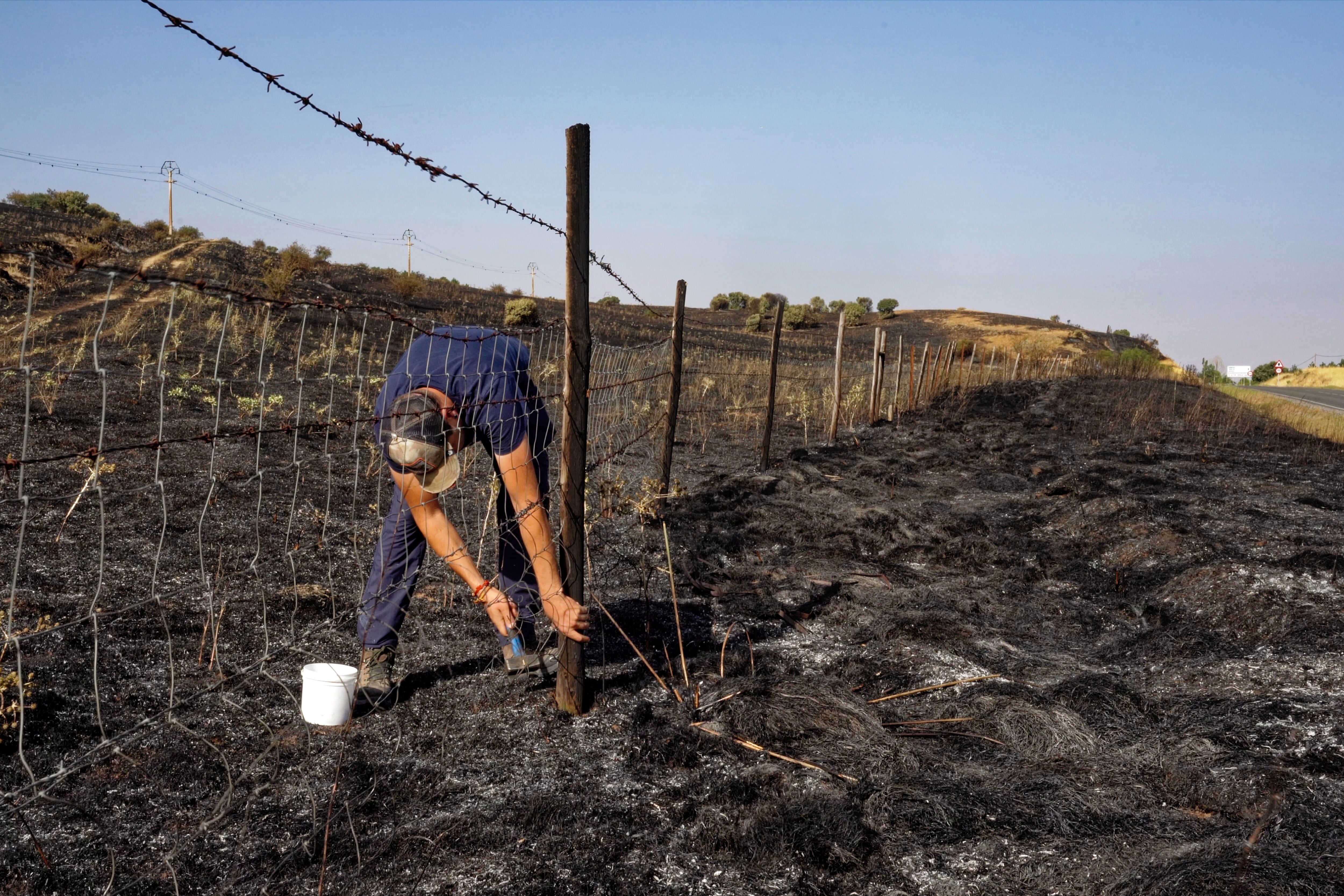  Un ganadero repara la valla de su finca afectada por el incendio en las proximidades de Urraca-Miguel