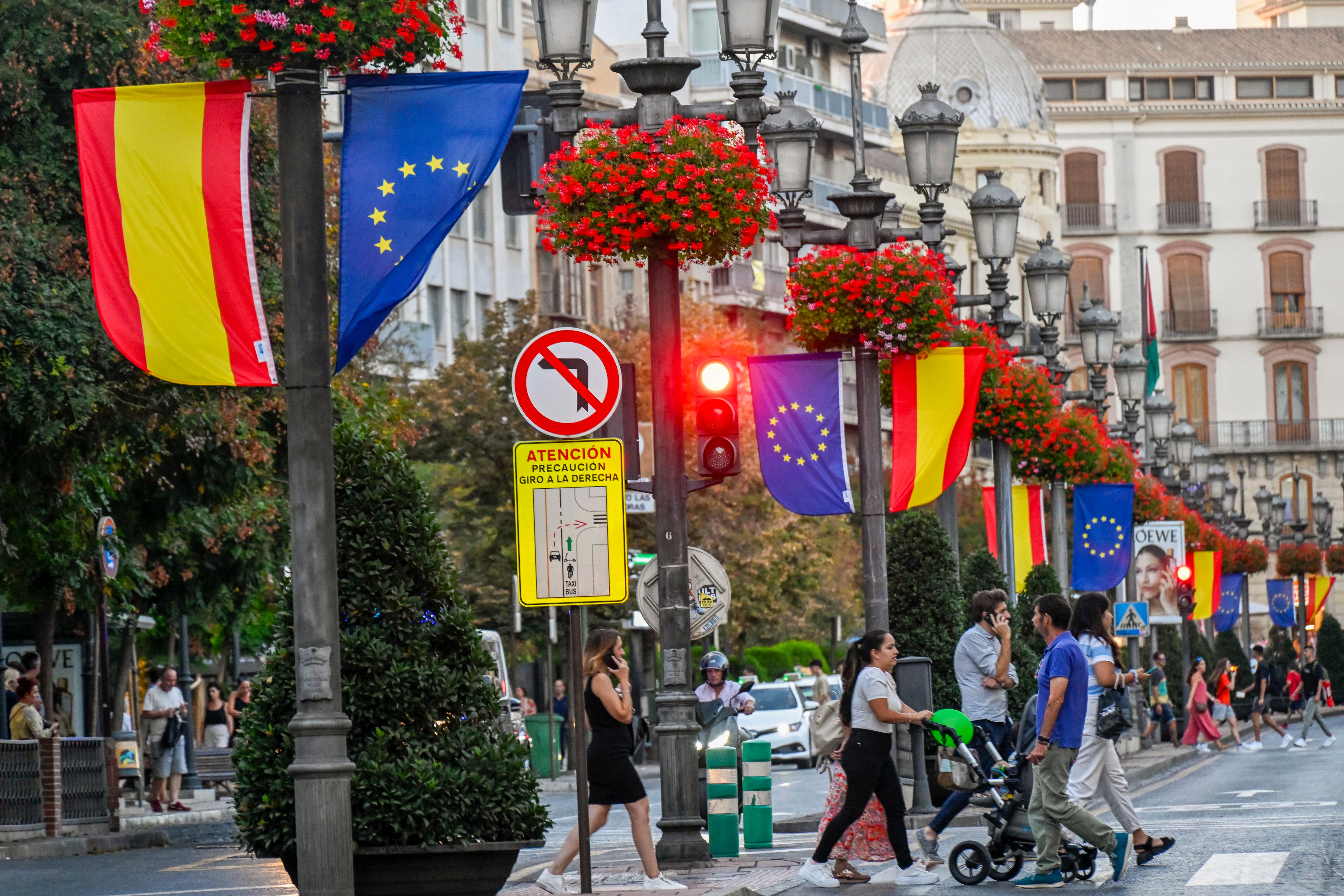 Varias personas caminan por las calles de Granada que alberga  la Cumbre de Jefes de Estado y de Gobierno de la Comunidad Política Europea