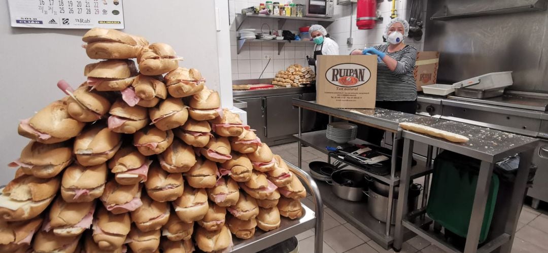 Muchos voluntarios contribuyen a hacer los bocadillos con embutido y pan donado de forma altruista