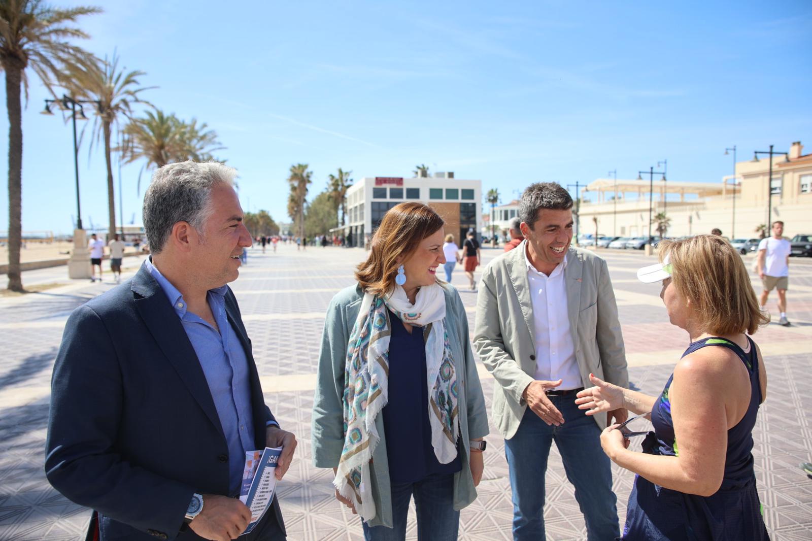 Elías Bendodo, María José Catalá y Carlos Mazón conversan con una mujer en el paseo marítimo de València