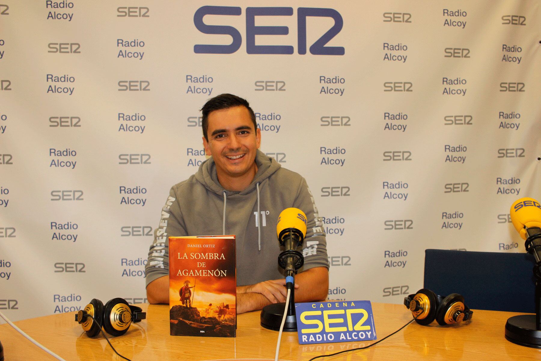 Dani Ortiz, en el estudio central de Radio Alcoy, con un ejemplar de su último libro