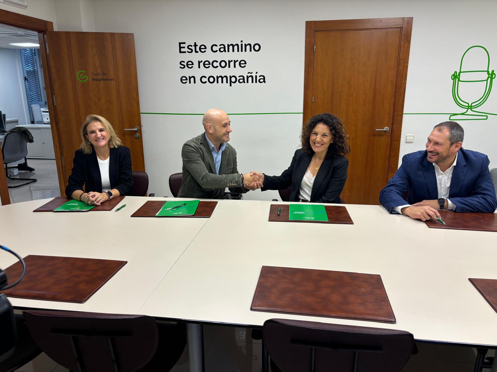 Magdalena Cantero, presidenta regional de la AECC y Miguel Ángel Lérida, vicepresidente del Colegio de Fisioterapeutas de Andalucía, sellan con las manos el acuerdo entre ambos colectivos.