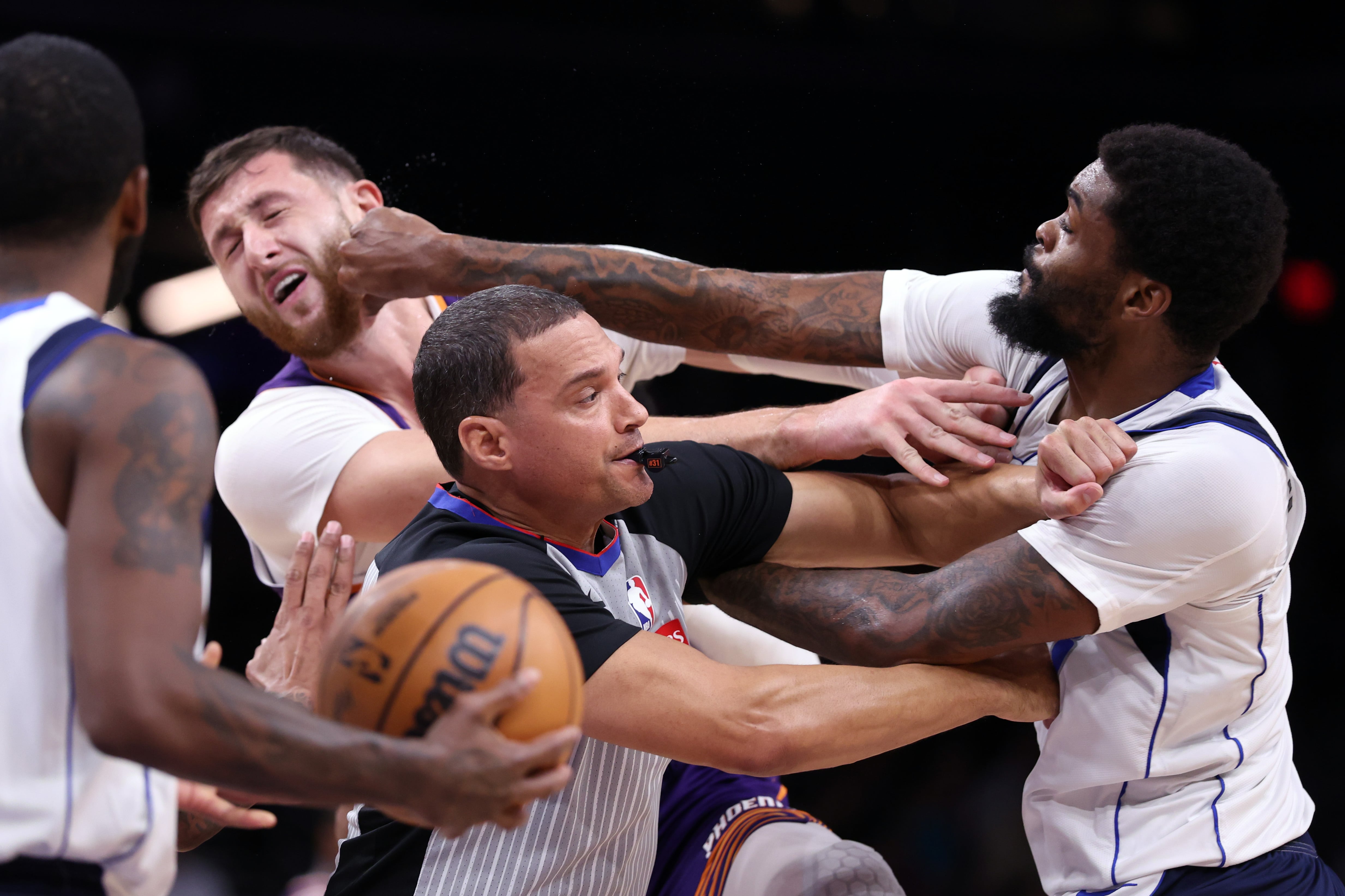 Naji Marshall, de Dallas Mavericks, da un puñetazo a Jusuf Nurkic, jugador de Phoenix Suns, durante una trifulca