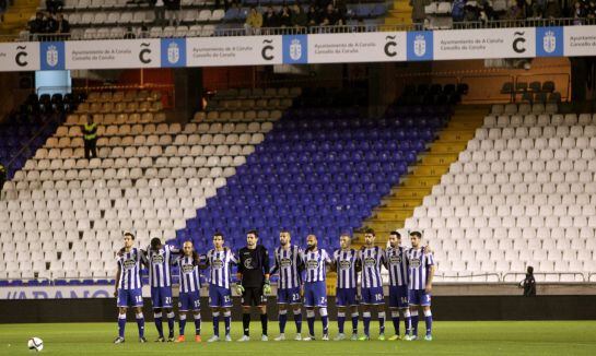 Los jugadores del Deportivo guardan un minuto de silencio por la muerte del aficionado que falleció el domingo en una reyerta entre ultras del equipo coruñes y el Atlético de Madrid, con la grada en la que se ubican los 'Riazor Blues' vacía.