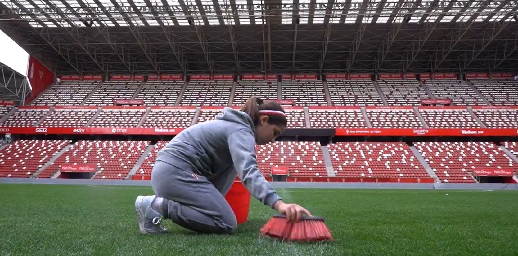 Imagen del vídeo del Sporting de Gijón en el que una jugadora limpia el césped de El Molinón.