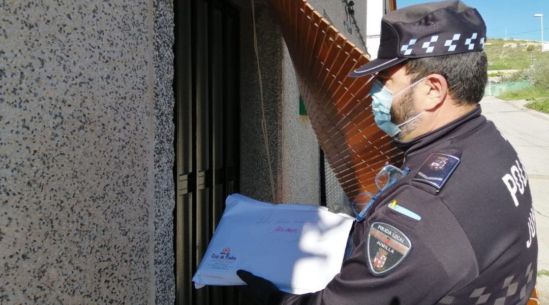 Agente de la Policía Local repartiendo material didáctico a los alumnos en sus domicilios