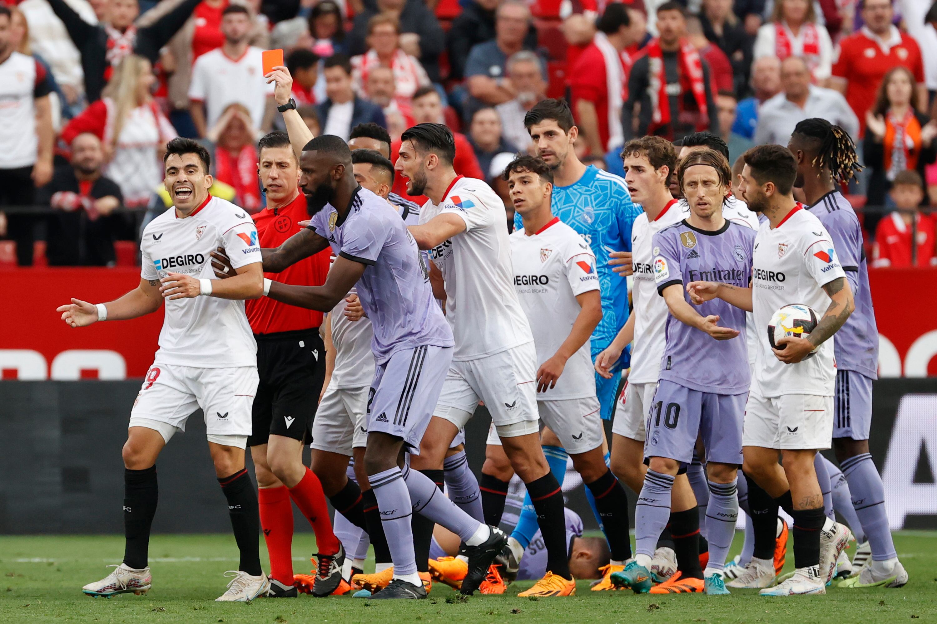 SEVILLA, 27/05/2023.- Marcos Acuña (i), del Sevilla, ve tarjeta roja tras una jugada con Dani Ceballos, del Real Madrid, durante el partido de la jornada 37 de LaLiga disputado este sábado en el estadio Sánchez Pizjuán. EFE/Julio Muñoz
