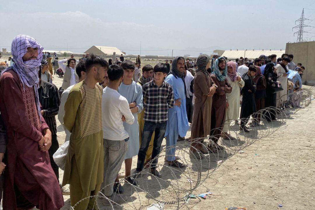 Afganos se reúnen frente al aeropuerto internacional Hamid Karzai para huir del país, después de que los talibanes tomaran el control de Kabul.