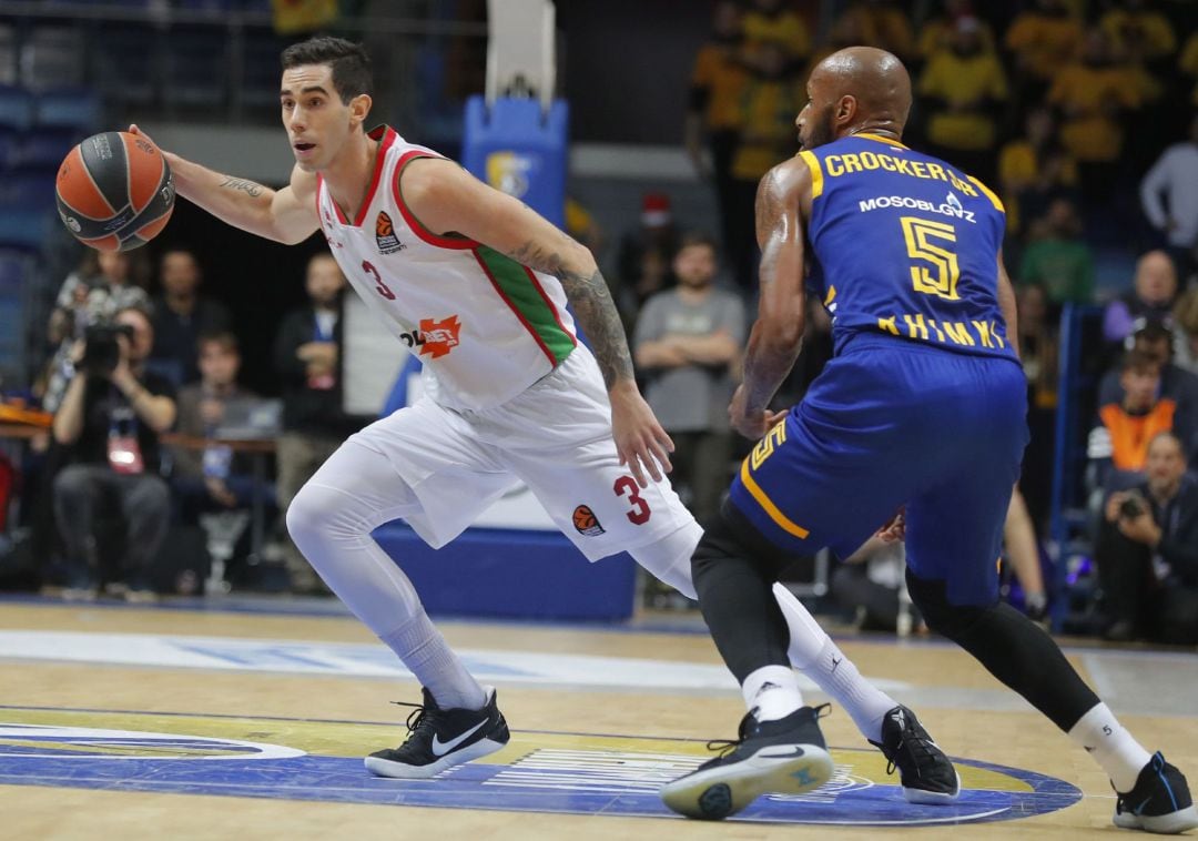 Luca Vildoza conduce el balón ante la defensa de Tony Crocker.