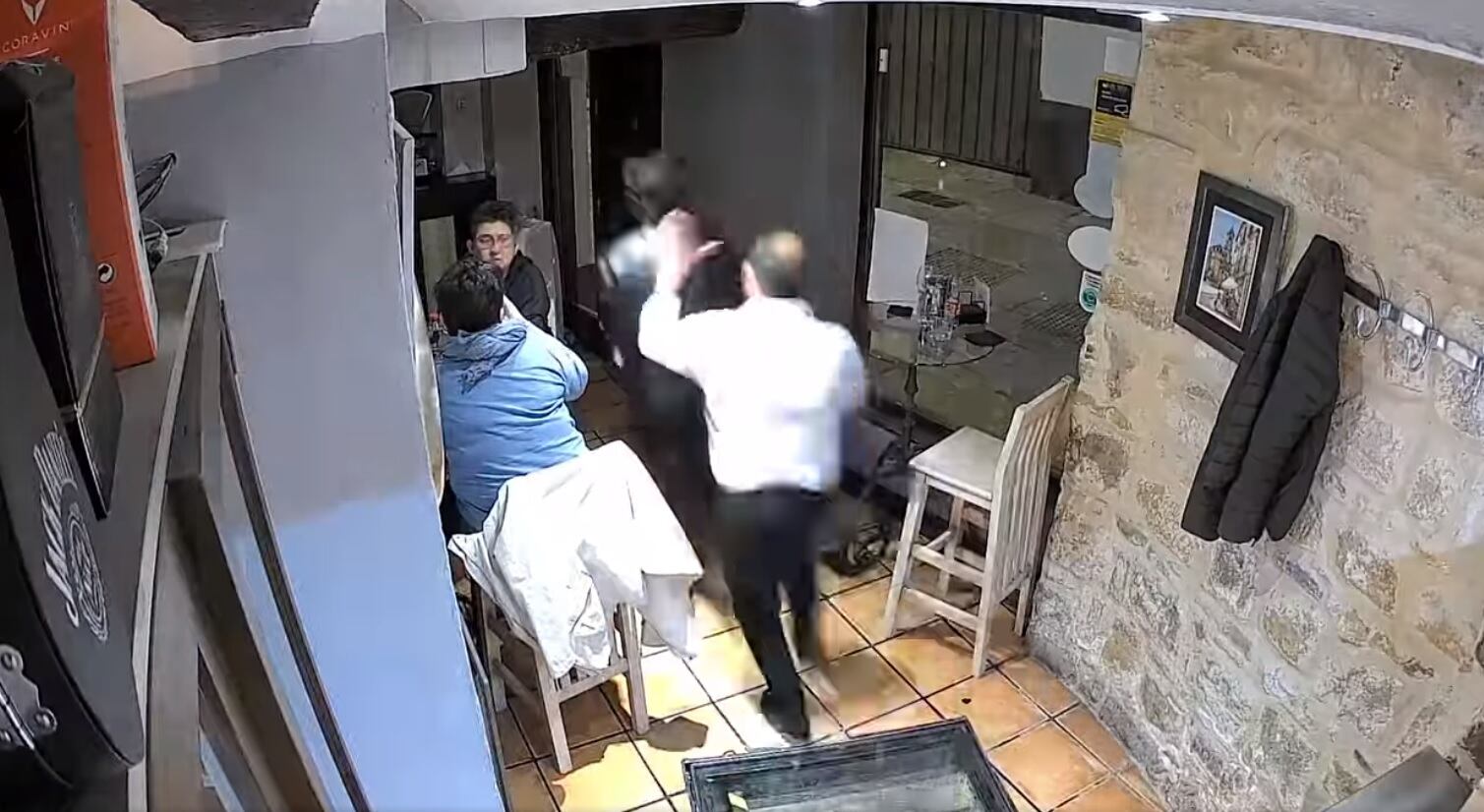 Momento en el que uno de los trabajadores del restaurante coge al ladrón saliendo del mismo.