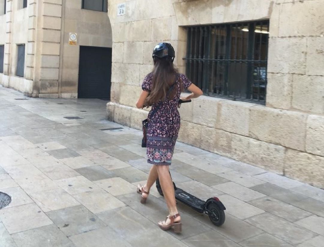 Una usuaria circula correctamente al bajarse del patinete por la acera