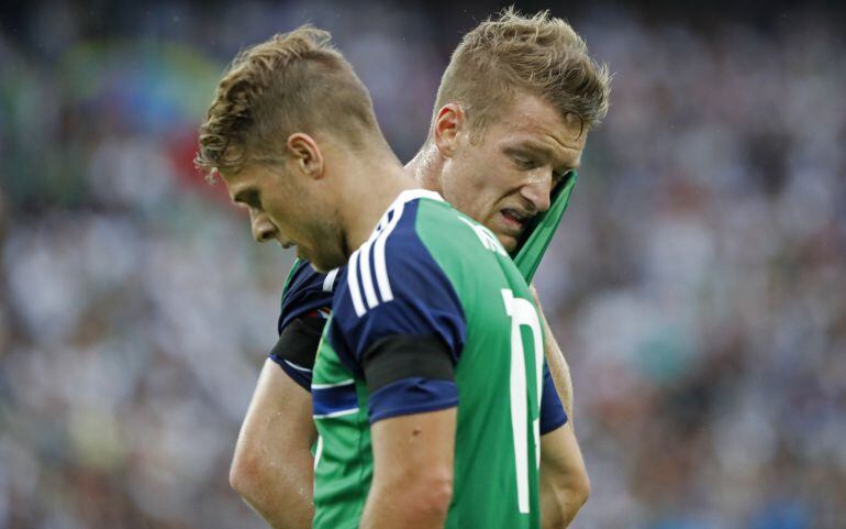 Dos jugadores de Irlanda del Norte charlan durante el partido ante Alemania