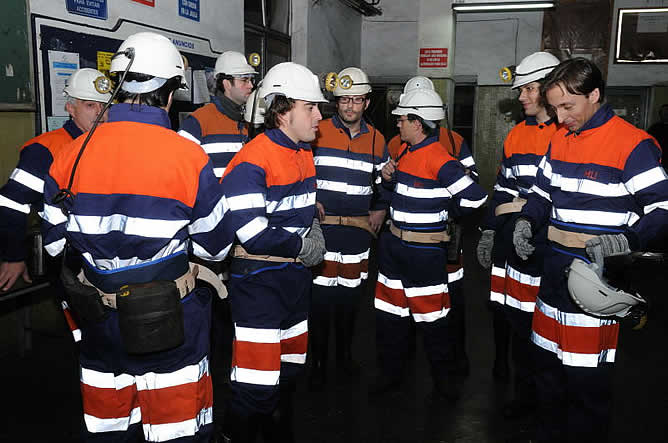 Fernando Alonso departiendo con los mineros del Pozo San Nicolás. A la derecha, Heri Frade y David Alonso, especialistas de motor de la SER. [Foto: Pedro Menéndez]
