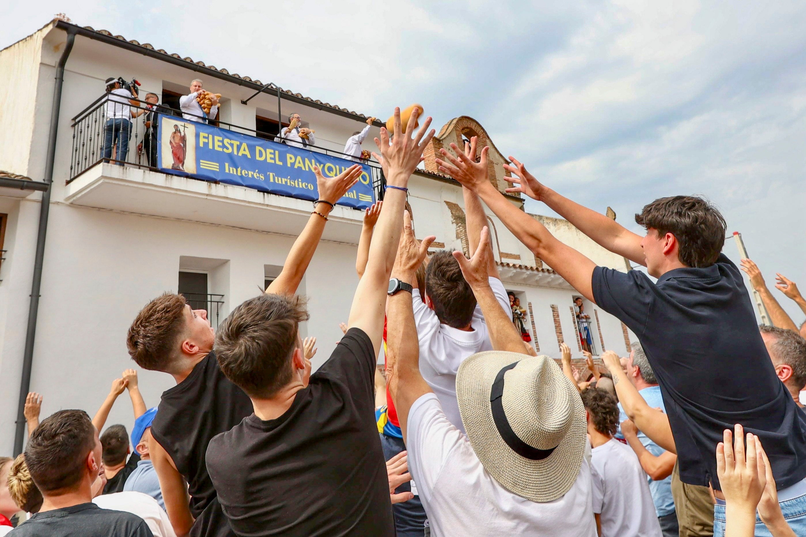 QUEL (LA RIOJA), 06/08/2025.- Unas 2.000 personas se han congregado este miércoles frente a la ermita de la Santa Cruz de Quel para conseguir los 2.500 bollos de pan y 60 kilos de queso de Roncal troceado en porciones que les han lanzado para revivir, como cada 6 de agosto, una tradición que data de 1479. EFE/ Raquel Manzanares