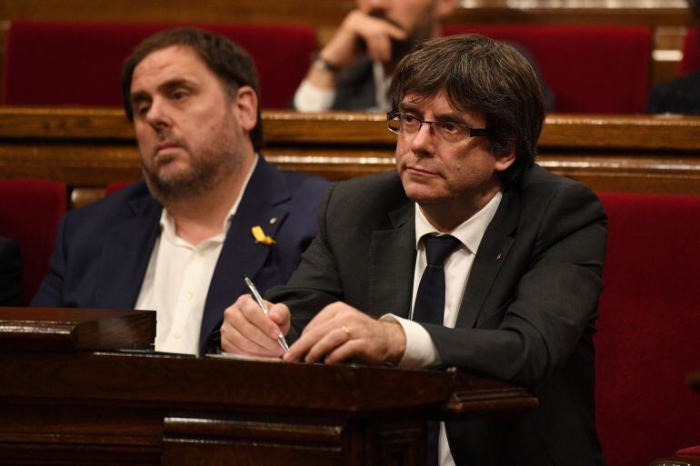 El president Carles Puigdemont, junto a Oriol Junqueras en el pleno del Parlament