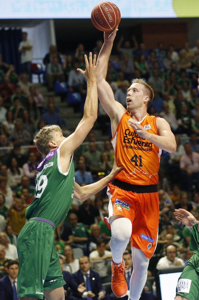 El alero lituano del Unicaja, Mindaugas Kuzminskas(i), intenta taponar el lanzamiento a canasta del ala-pivot estadounidensedel Valencia Basket Club, Justin Halminton(d) durante el partido disputado esta tarde en el palacio de los deportes Jose María Mart