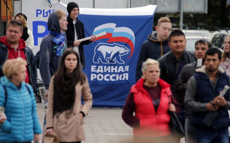 Un grupo de peatones camina junto a un cartel electoral del partido Rusia Unida en San Petersburgo, Rusia hoy, 16 de septiembre de 2016. La elecciones parlamentarias se celebran el próximo 18 de septiembre. 