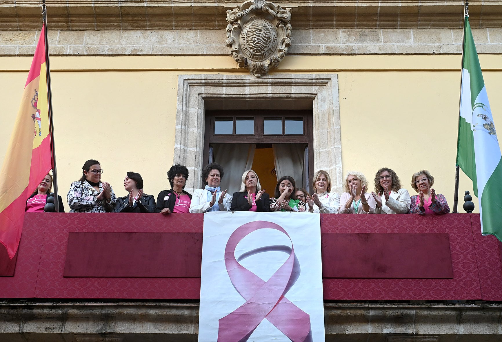 Colocación de lazo rosa contra el cáncer de mama en el balcón del Ayuntamiento de Jerez