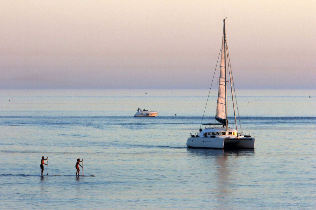 Varias personas disfrutan de deportes acuáticos en la playa de La Malagueta
