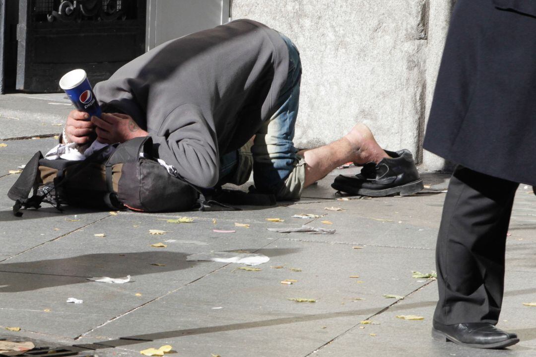 Pobreza, persona pidiendo en la calle, foto de archivo