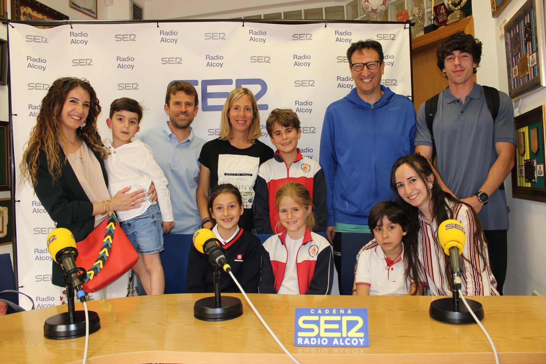 Foto de familia con los jóvenes artistas y sus familias que han estado en el estudio central de Radio Alcoy, junto a la presidenta de Tesalín, Noemí Fraj