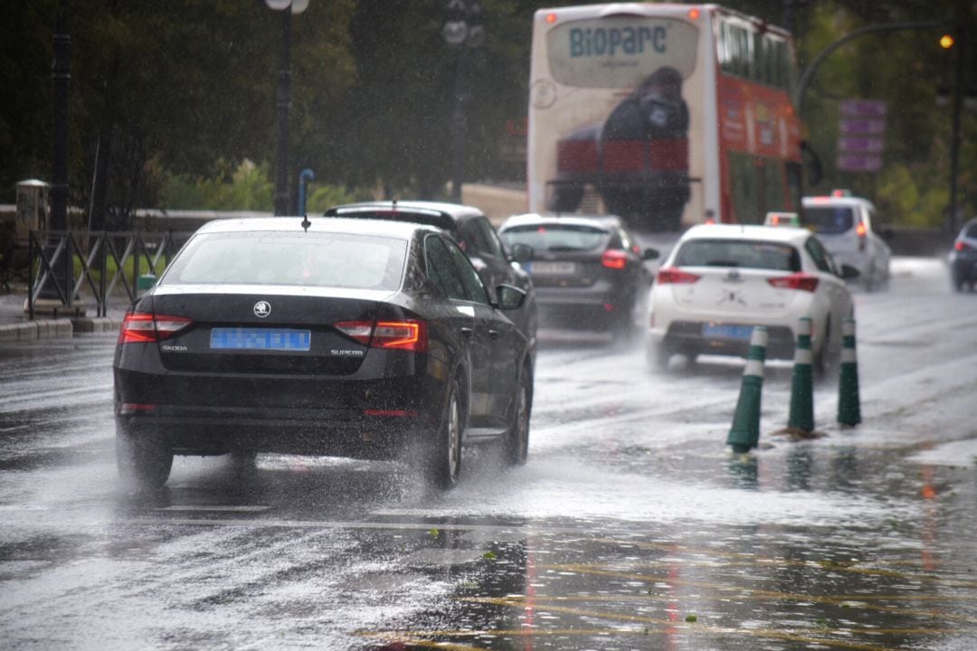 Varios coches circulan por una calle de València