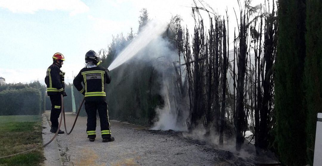 Dos bomberos apagan el fuego que ha tenido lugar en el parque Andrés de Vandelvira.