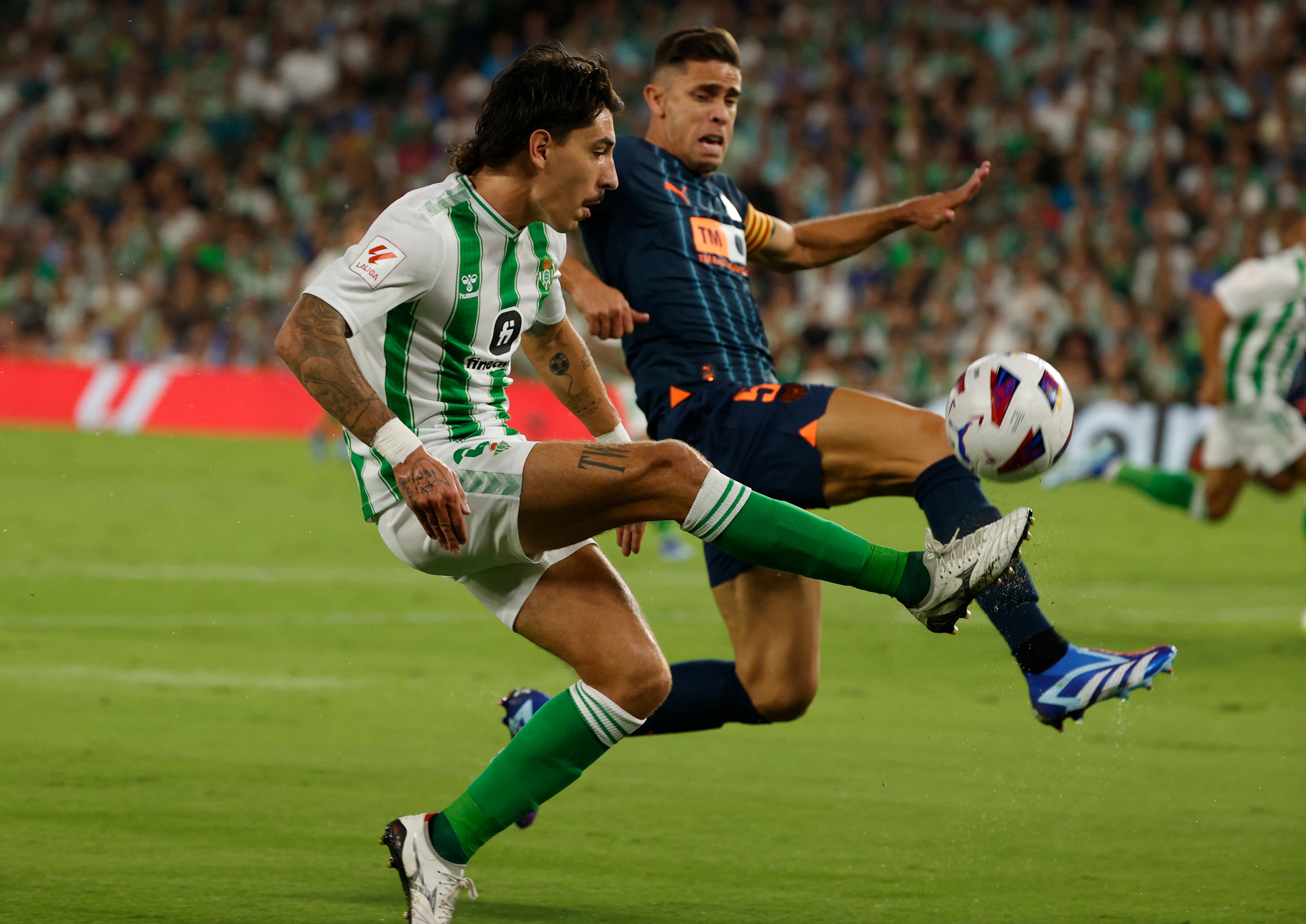 SEVILLA, 01/10/2023.- El lateral del Betis Héctor Bellerín (i) pelea un balón con Gabriel Paulista, del Valencia, durante el partido de la octava jornada de LaLiga que Real Betis y Valencia CF disputan hoy domingo en el estadio Benito Villamarín, en Sevilla. EFE/Julio Muñoz