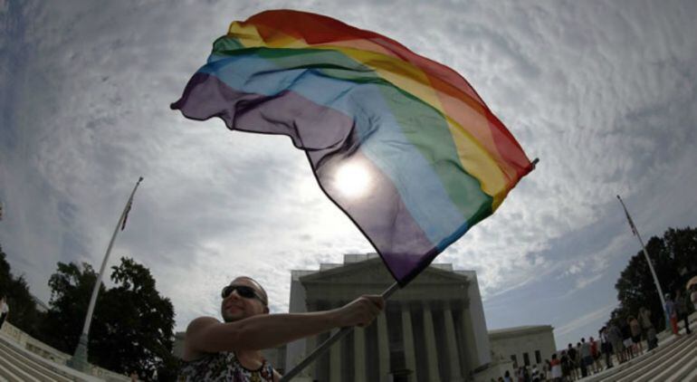 Un hombre ondea una bandera gay