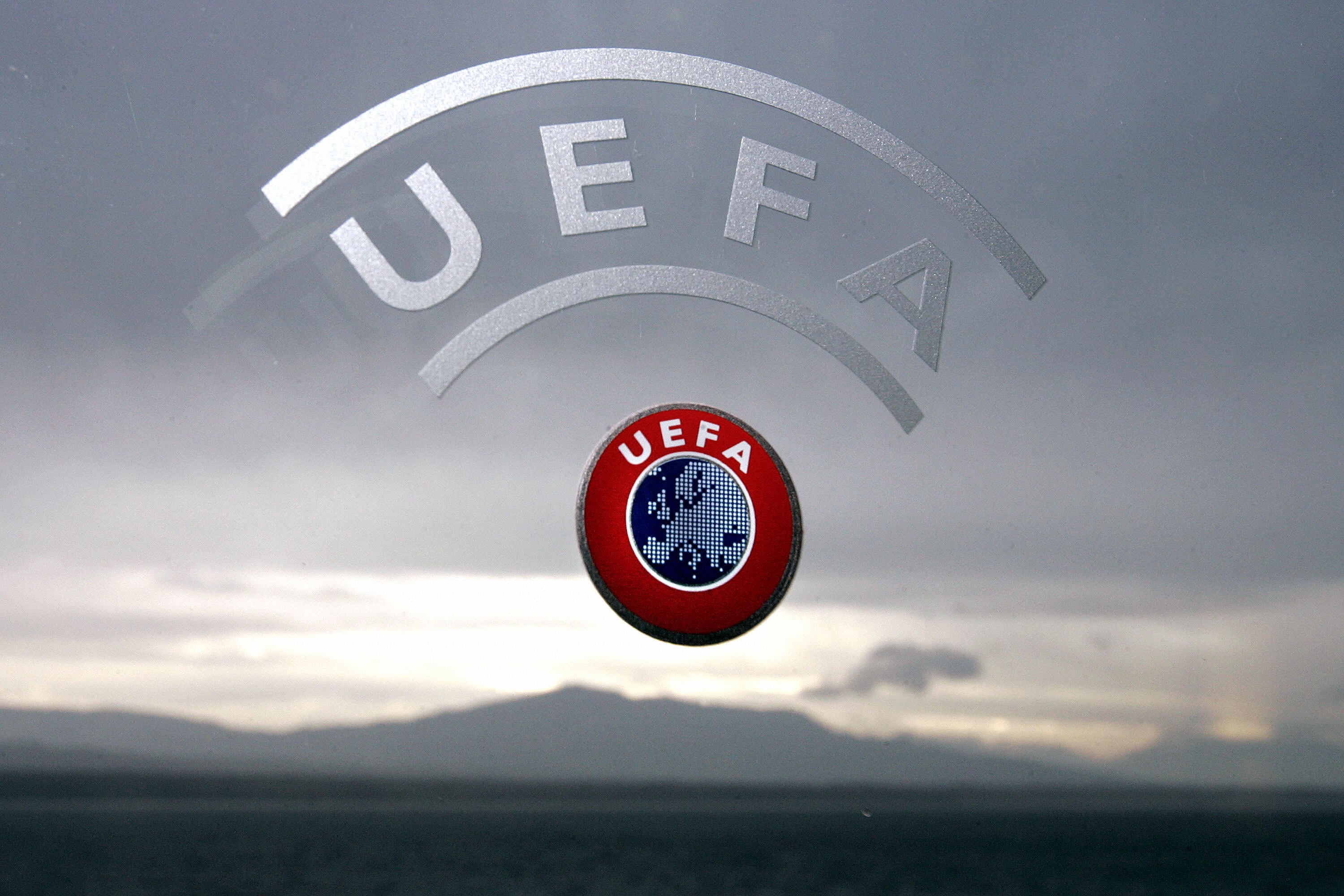 Nyon, SWITZERLAND:  A UEFA logo is seen with Geneva Lake and Alps as background 08 December 2006 during a press conference closing a two days Executive committee meeting of the European football federation at the headquarters in Nyon. AFP PHOTO / FABRICE COFFRINI  (Photo credit should read FABRICE COFFRINI/AFP via Getty Images)